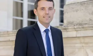 Alexandre Portier, souriant, en costume sombre, prêt pour son mariage.