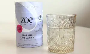 Opakowanie Zoe Nutrition Marine Collagen o smaku malinowym obok szklanki. Czy warto kupić? Sprawdź collagen drink dr max opinie.