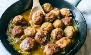 Polpette in bianco dorate e succulente, cotte in padella con cipolle dolci e un sughetto invitante. Un classico confortante.