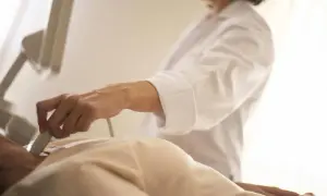 Lekarz wykonuje USG szyi pacjentowi, który czeka na wyniki badań, być może związane z bisocard na uspokojenie.