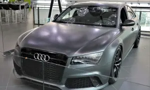 Matowy, szary Audi RS8 z czarnymi felgami i detalami, prezentowany w salonie.