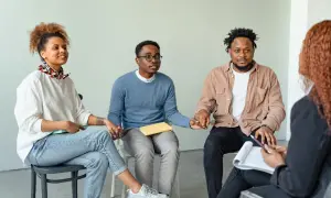 Grupo de personas en círculo, tomándose de las manos, fortaleciendo sus relaciones de amistad y apoyo mutuo.