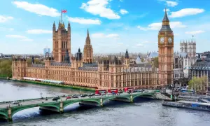 Parlamentshuset och Big Ben i London, med en bro och trafiken som visar det typiska klimat london.