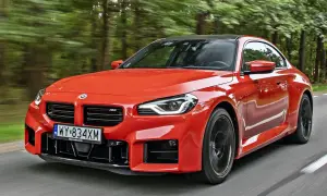 Pomarańczowe BMW M2 pędzi leśną drogą. Sprawdź aktualną bmw m2 cena i poczuj moc!