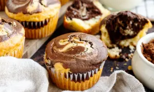 Marmorierte Muffins, perfekt für ein schnelles Muffins Rezept. Ein Muffin ist angeschnitten und zeigt den saftigen Teig.