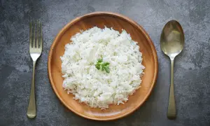 Piatto di riso bianco, forchetta e cucchiaio. Potrebbe essere l'inizio della dieta del riso 4 kg in 7 giorni.