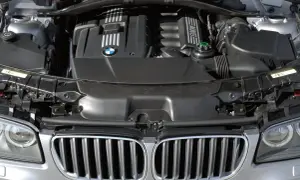 Silnik BMW X3 2005. Widok komory silnika z charakterystyczną atrapą chłodnicy i logo BMW.