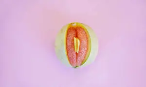 En melon skuren på mitten, med saftigt rött fruktkött som påminner om ett svullet underliv gravid.