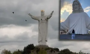 Największy pomnik Jezusa na świecie, z koroną na głowie i rozłożonymi ramionami, majestatycznie góruje nad krajobrazem.