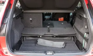 Bagagliaio aperto Volvo XC40, con sedili abbassati per massimizzare le volvo xc40 dimensioni. Si intravede un kit di pronto soccorso.
