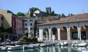 Porto di Desenzano: cosa vedere? Barche ormeggiate, case colorate e torri antiche sul lago.