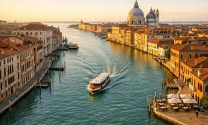 Widok na Canal Grande w Wenecji, z łodzią i bazyliką Santa Maria della Salute. Idealne miejsce, by zacząć odkrywać, co zwiedzić w Wenecji.
