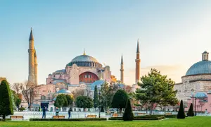 Majestatyczna Hagia Sophia w Stambule, z jej kopułą i minaretami, góruje nad zielonym parkiem.