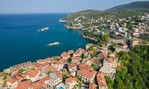 Widok z lotu ptaka na malowniczą ulcinj plaża z kamiennymi domami i turkusowym morzem.
