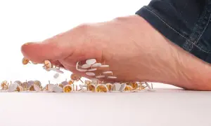 Piedi che calpestano puntine, metafora del dolore neuropatia arti inferiori cura.