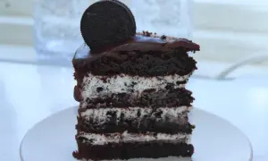 En bit chokladkaka med lager av krämig fyllning och krossade oreos. En hel oreo kex toppar denna läckra oreo tårta.