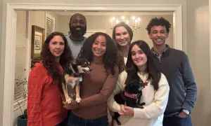 La familia anfitriona posa sonriente con sus dos perros.