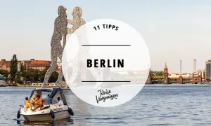 11 Tipps für Ihren Besuch in Berlin: Eine Bootsfahrt auf der Spree mit Blick auf die Oberbaumbrücke und die Skulptur "Molekularmensch".