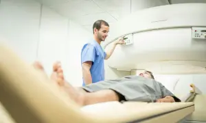 Un technicien ajuste les commandes d'un appareil d'IRM, prêt à examiner la prostate d'un patient allongé sur la table d'examen.