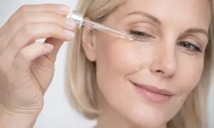 Kobieta aplikuje serum z niacynamidem pod oczy. Efekt niacynamid przed i po widoczny na skórze.