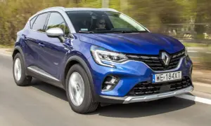 Błękitny Renault Captur 2019 pędzi po drodze, kierowca w okularach obserwuje trasę.