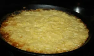 En gyllene potatiskaka med parmesan, nybakad i gjutjärnspanna. Låter det inte gott?