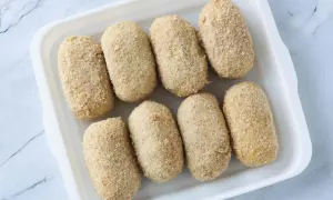 Ocho croquetas empanadas listas para cocinar en la airfryer.