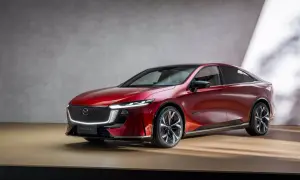 Elegancka, czerwona Mazda 6e prezentuje się na drewnianej scenie.