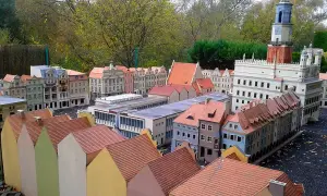 Miniaturowa zabudowa miejska z wieżą zegarową i kolorowymi domkami w skansenie.