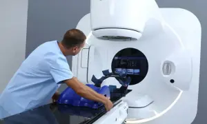 Medyk przygotowuje pacjenta do radioterapii na nowoczesnym urządzeniu Elekta.