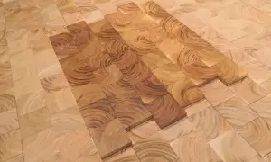 Patrón de suelo de madera cerezo con vetas circulares, algunas piezas más oscuras que otras, creando un efecto de degradado.