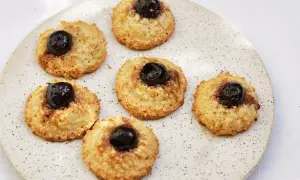 Sju italienska mandelkakor med körsbär på en prickig tallrik.