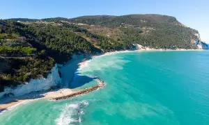 Spiaggia di Numana con scogliere bianche, mare turchese e pineta. Ecco cosa vedere a Numana per un panorama mozzafiato.