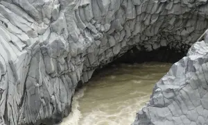 Die Alcantara Schlucht in Sizilien zeigt faszinierende Basaltsäulen, die von einem türkisfarbenen Fluss umspült werden.