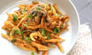 En krämig pasta boscaiola med svamp och persilja, serverad i en vit skål.