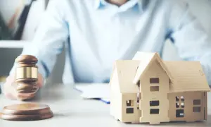 Martelletto da giudice e modello di casa, suggeriscono un possibile pignoramento immobiliare fac simile.