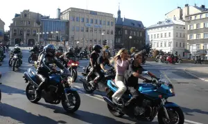 Zloty motocyklowe w mieście. Grupa motocyklistów w kaskach i skórzanych ubraniach przemierza ulicę na swoich maszynach.