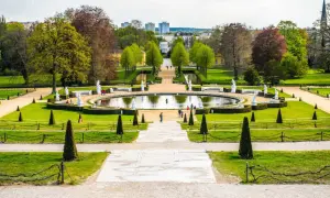 Ein prächtiger Park mit einem runden Teich, Statuen und gepflegten Rasenflächen. Ein ideales Motiv für Ausflugsziele Potsdam.