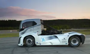 Le camion de course "The Iron Knight" blanc et argenté, numéro 26, sur une piste au coucher du soleil.