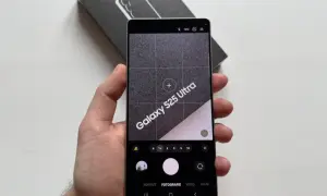 Ręka trzyma telefon Samsung Galaxy S25 Ultra z otwartą aplikacją aparatu. Widoczne opcje: portret, fotografia, wideo. Dowiedz się, jak ustawić aparat w telefonie Samsung.