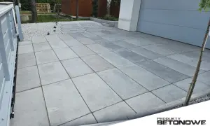 Nowoczesne układanie płyt granitowych na betonie tworzy elegancką nawierzchnię podjazdu.