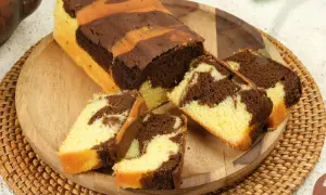 Babka marmurkowa z czekoladą i wanilią, pokrojona na plastry, na drewnianej desce.