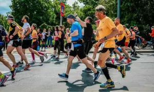 Grupa biegaczy podczas zawodów. Czy bieganie odchudza? Ci uczestnicy z pewnością próbują to udowodnić, pokonując kolejne metry trasy.
