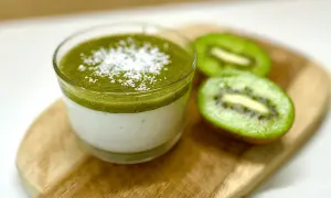 Panna cotta au lait et coulis de kiwi, saupoudrée de noix de coco râpée. Une recette légère et fruitée.