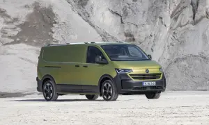 Un furgone Volkswagen Transporter color verde oliva, con un design moderno e robusto, pronto per ogni avventura. Le sue dimensioni sono perfette per il trasporto.