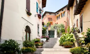Un vicolo fiorito nel gardone riviera centro storico, con scale di pietra, case colorate e piante rigogliose.