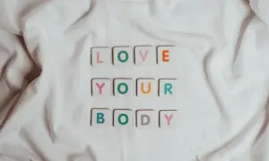 Kolorowe kafelki z literami układają się w napis "LOVE YOUR BODY". To piękna afirmacja, która przypomina o akceptacji siebie.