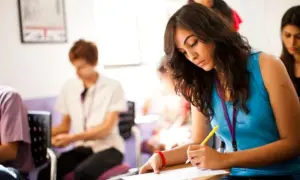 Jóvenes concentrados en un examen, quizás el ejemplo examen habilitación lingüística Madrid.