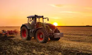 Un tracteur, c'est ce puissant engin vert et rouge qui travaille la terre au coucher du soleil, préparant le champ pour les futures récoltes.