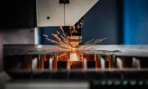 Precyzyjne cięcie metalu przez laser, gdzie iskry rozchodzą się jak fajerwerki. Różne rodzaje frezów pozwalają na tworzenie skomplikowanych kształtów.